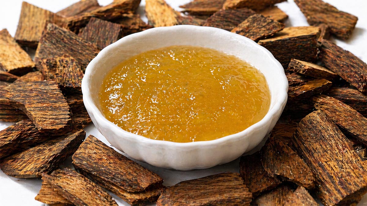 Guaiacwood Essential Oil in bowl surrounded by guaiacwood chips